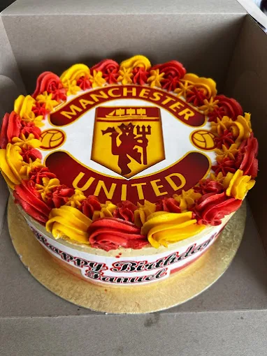 A custom celebration cake decorated with red and yellow icing and an edible topper